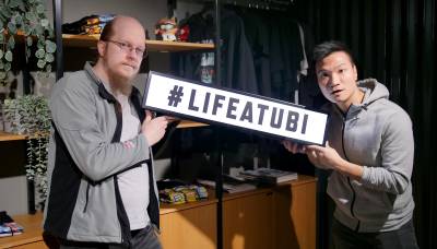 Two team members holding a placate with a Life at Ubi hashtag.