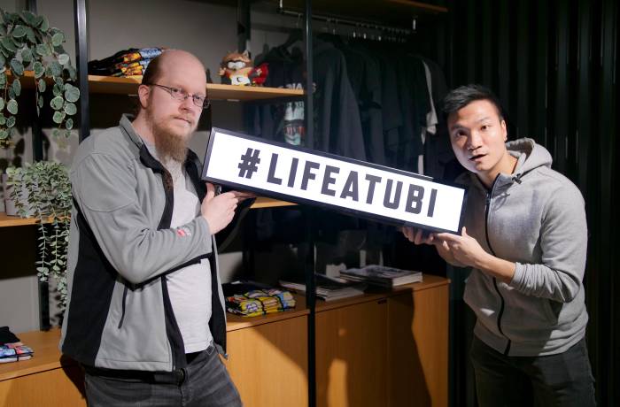 Two team members holding a placate with a Life at Ubi hashtag.